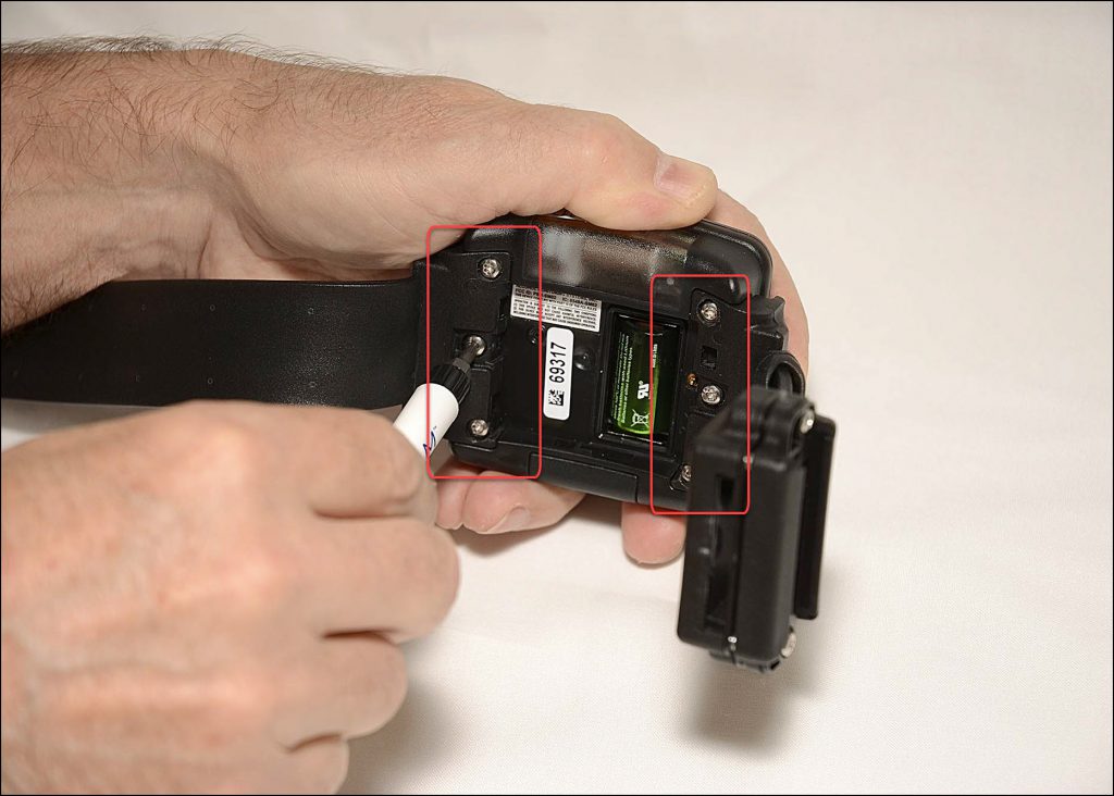 A hand holding a camera Description automatically generated