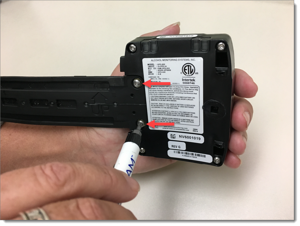 A T 10 screwdriver removing screws from the bracelet strap